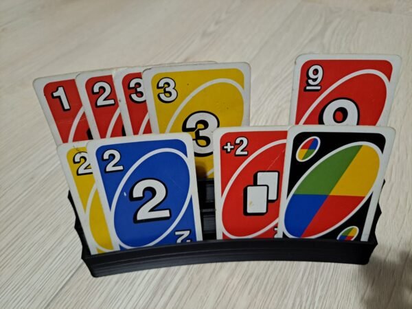 UNO-kortit asetettuna mustaan korttitelineeseen