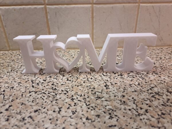 HOME-koriste sydämellä – valkoinen sisustusteksti