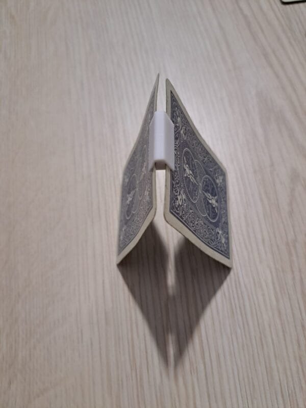 Kaksi pelikorttia yhdistettynä 3D‑tulostetulla liittimellä