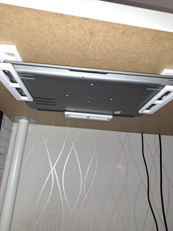 Kannettava tietokone kiinnitettynä pöydän alle valkoisilla pidikkeillä