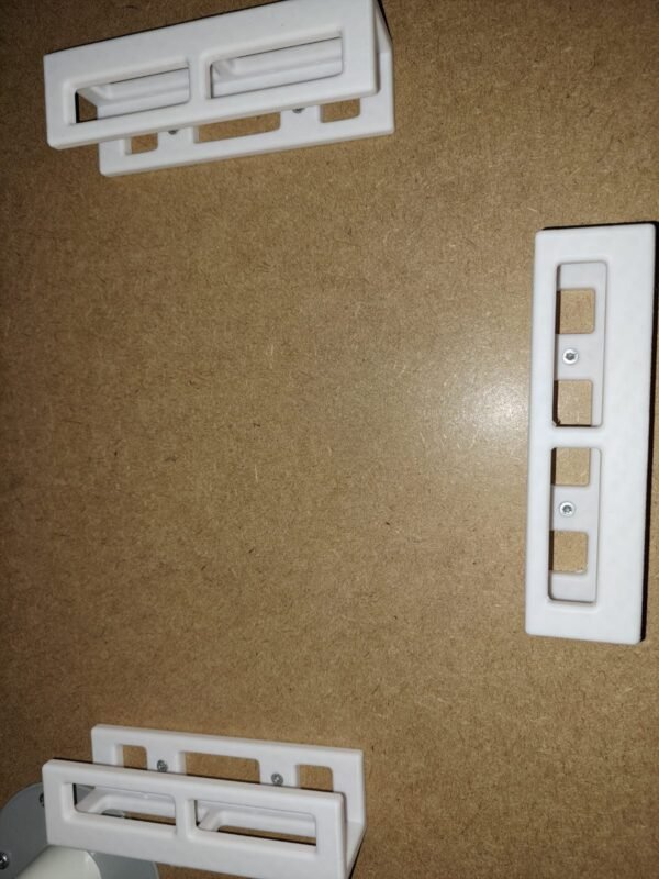 Valkoiset muoviset pidikkeet kiinnitettynä pöydän alapintaan