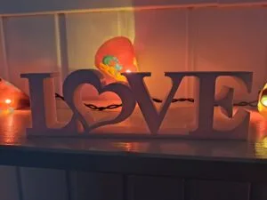LOVE‑koriste sydämellä valkoisena sisustuselementtinä