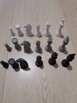 3D‑tulostetut shakkinappulat musta, harmaa ja valkoinen