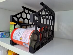 Musta muovinen tölkkiteline keittiön kaapissa säilykepurkeille