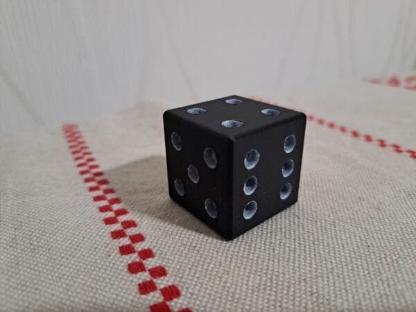 Musta 3D‑tulostettu noppa sileällä pinnalla