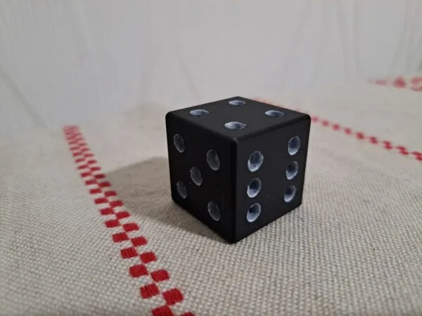 Musta 3D‑tulostettu noppa sileällä pinnalla