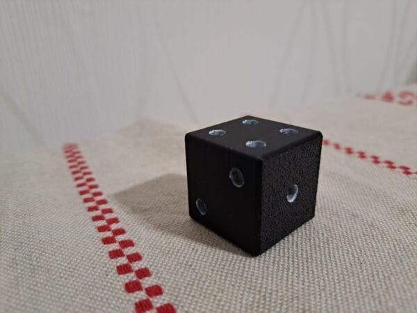 Musta 3D‑tulostettu noppa teksturoidulla pinnalla