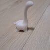Minimalistinen valkoinen muovinen dino-sormusteline