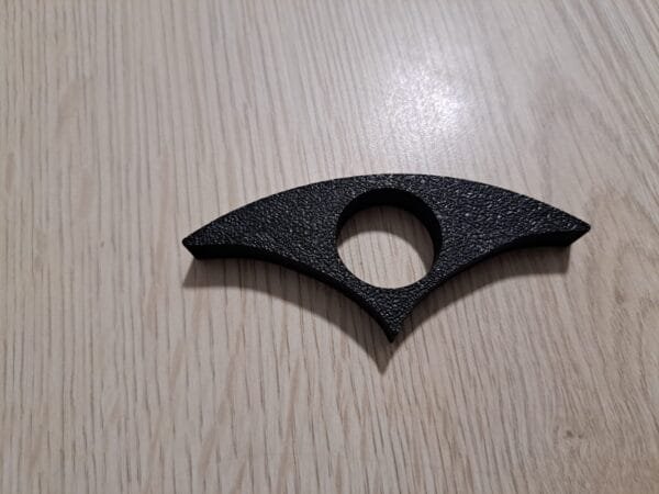 Musta muovinen kirjan sivunpidin pöydällä