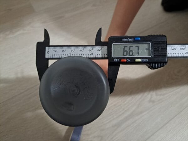 Työntömitta mittaamassa juomapullon halkaisijaa.